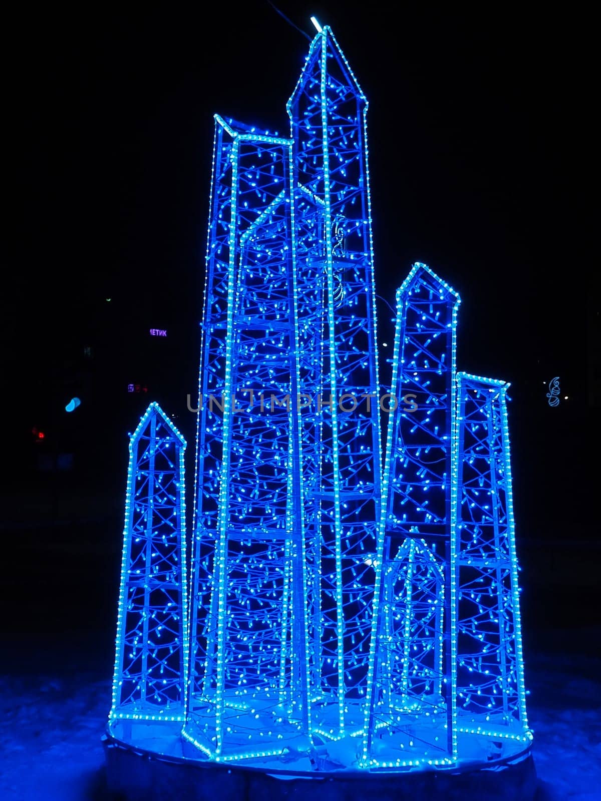 Garlands with glowing blue light. Iceberg or ice crystals as decoration. Street decor for New Year or Christmas. Blue bokeh lights. Evening or night in the north