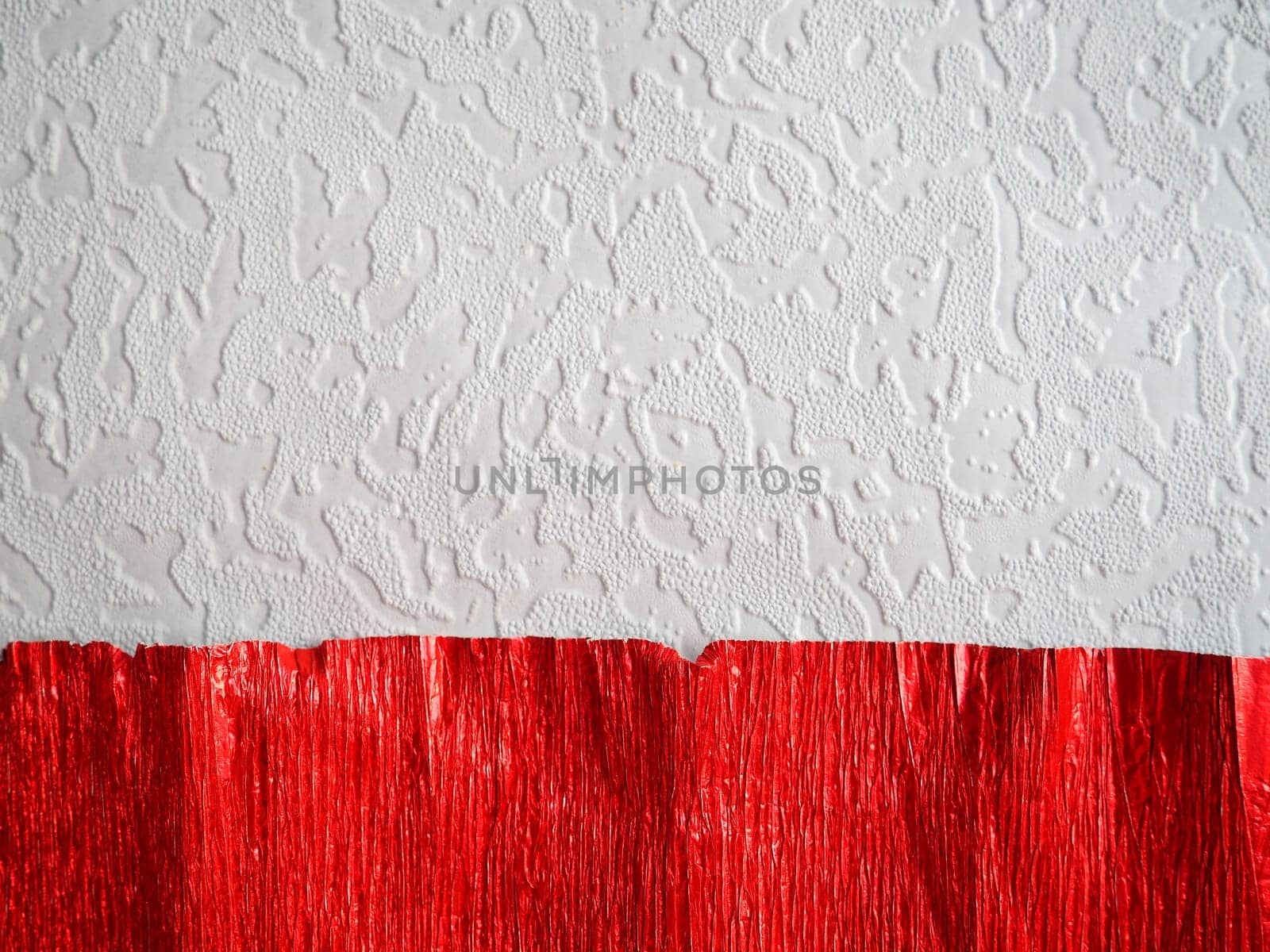 Corrugated paper in red. Uneven surface. Abstract background. Wavy edges of the paper sheet. Lighting gradient.