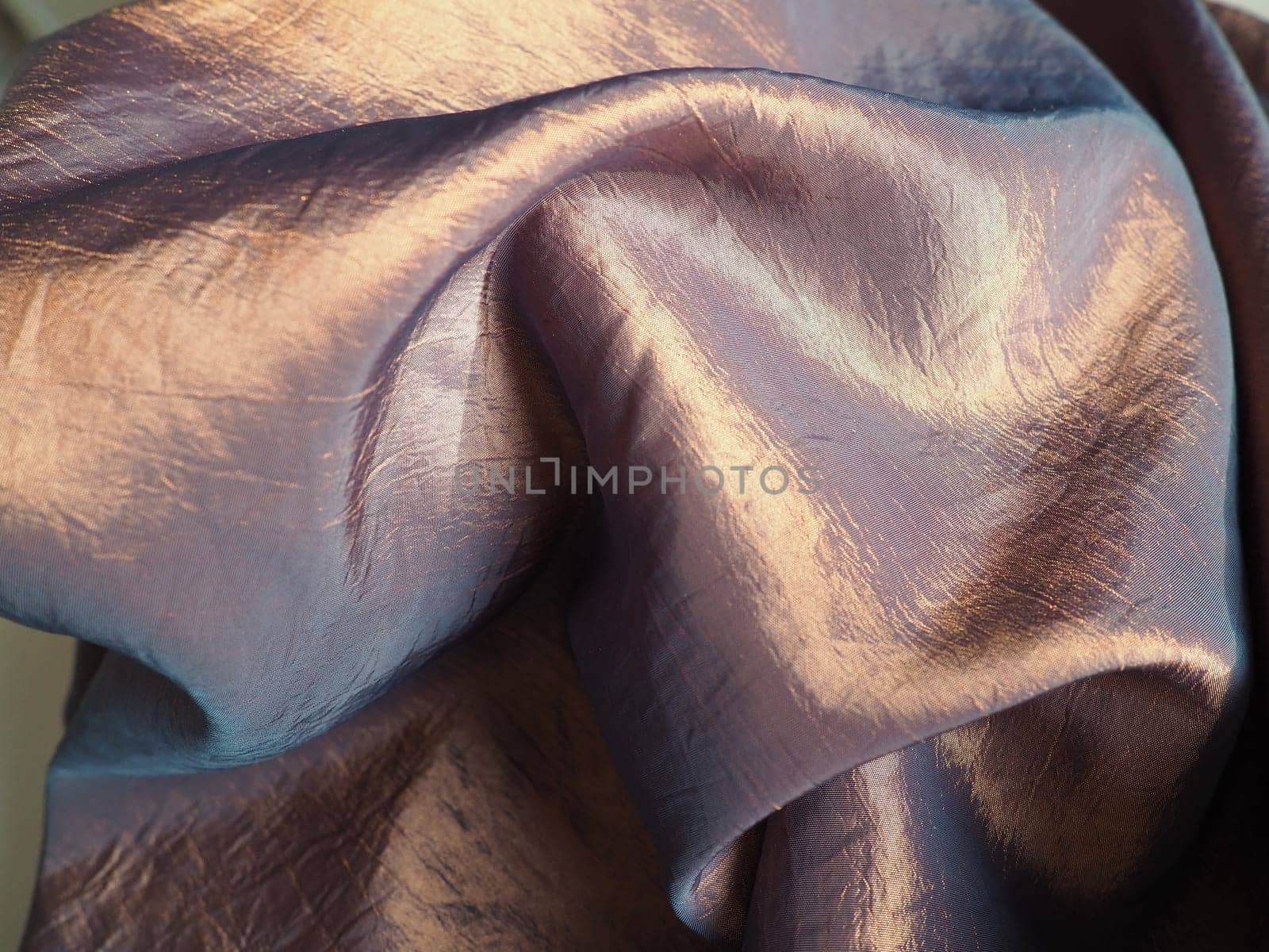 Beautiful fabric - taffeta, gently folded in waves. Crumpled material that looks like silk or brocade. Overflow and color gradient at different lighting angles. Fabric for sewing clothes and curtains.