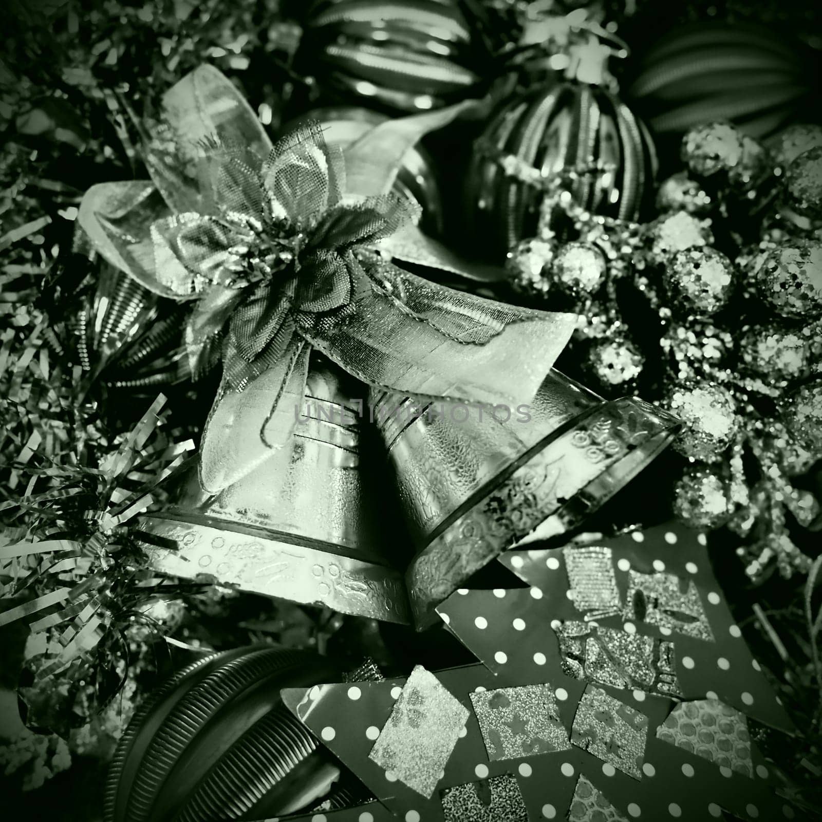 Christmas background with Christmas decorations, holiday balls, bells, bows, dots, fir cone, Christmas tinsel. Happy New Year and Merry Christmas. Black and white monochrome photo with green filter