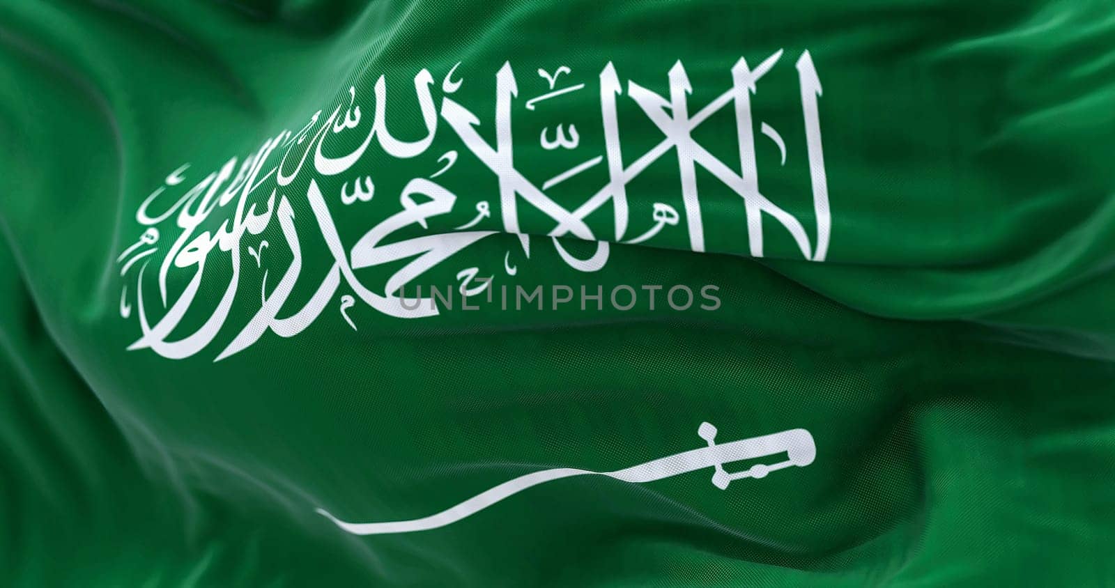 Close-up view of Saudi Arabia national flag waving in the wind. The Kingdom of Saudi Arabia is a country in Western Asia. Fabric textured background. Selective focus. Realistic 3d illustration