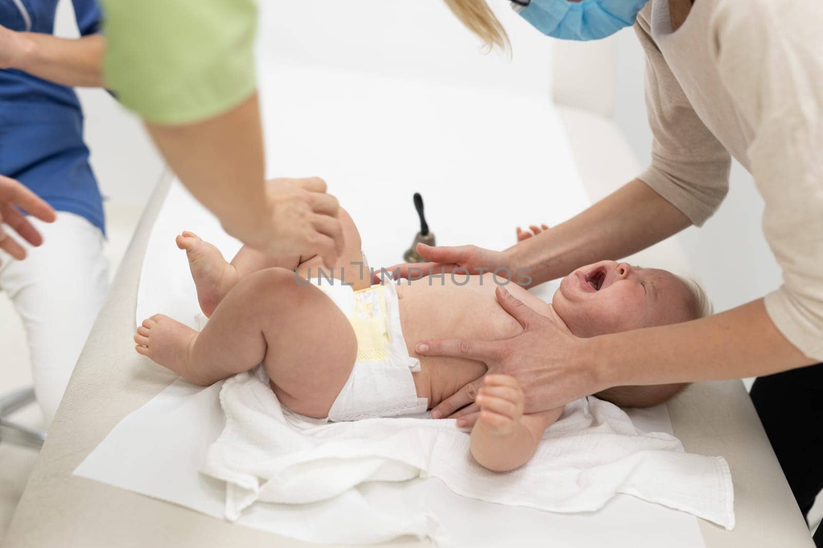 Baby beeing vaccinated by pediatrician in presence of his mother. Preventive vaccination against Diphtheria, whooping cough, tetanus, hepatitis, haemophilus influenzae, pneumococcus, poliomyelitis.
