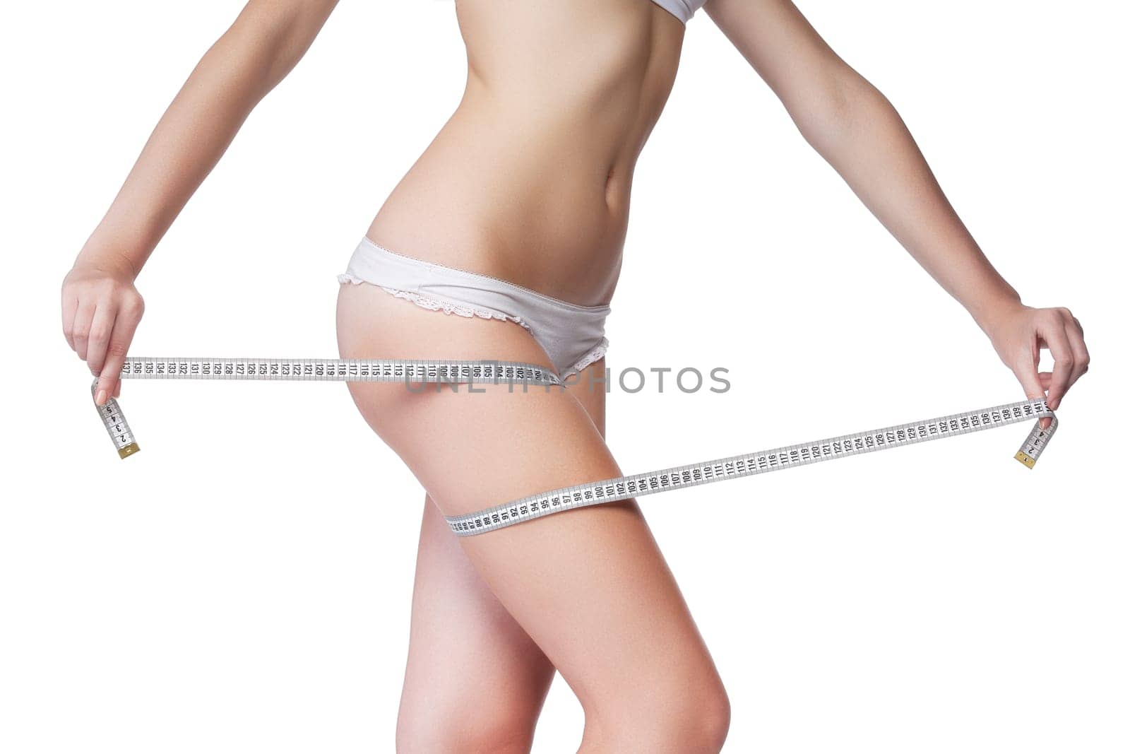 Woman measuring her thigh using a tape measure, isolated on white background