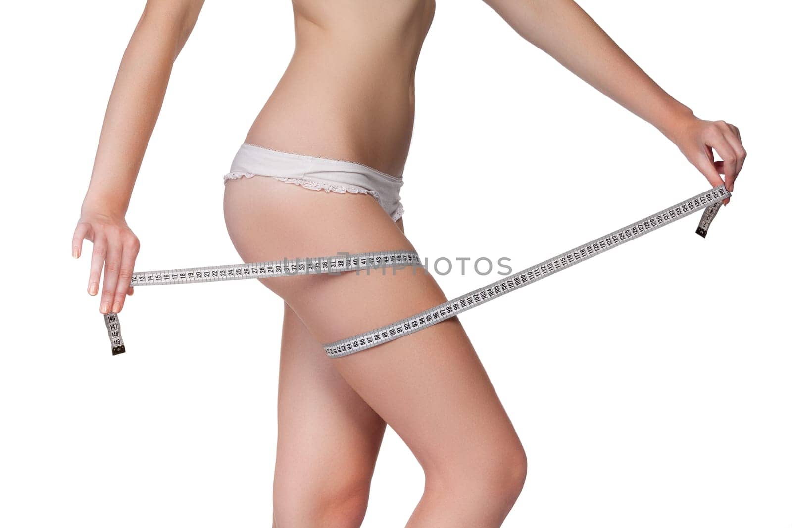 Woman measuring her thigh using a tape measure, isolated on white background