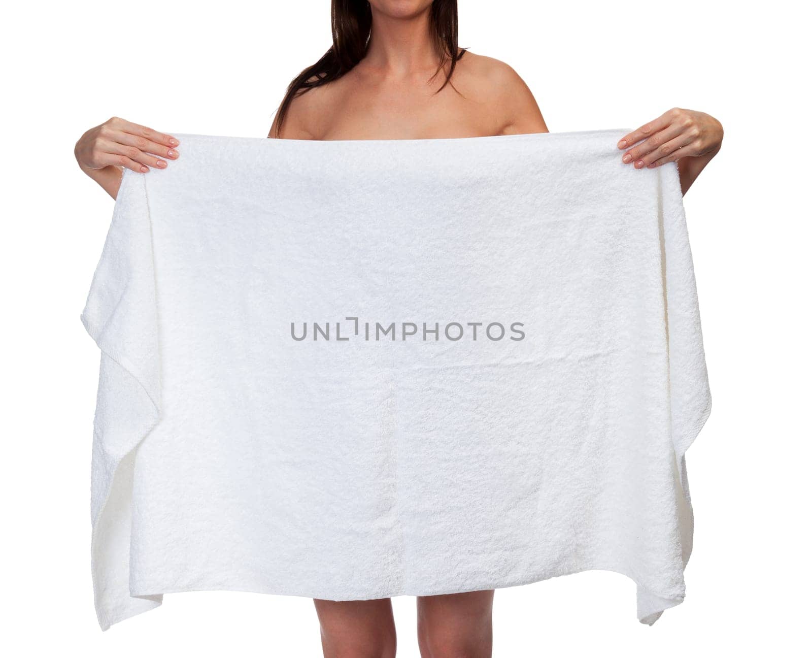 Tanned woman holding a white towel and covering herself, isolated on white background.