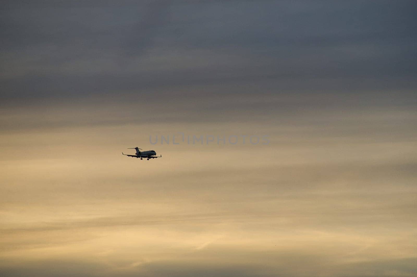airplane in the evening sky in luminous horizon. vacation trip or cargo transport.