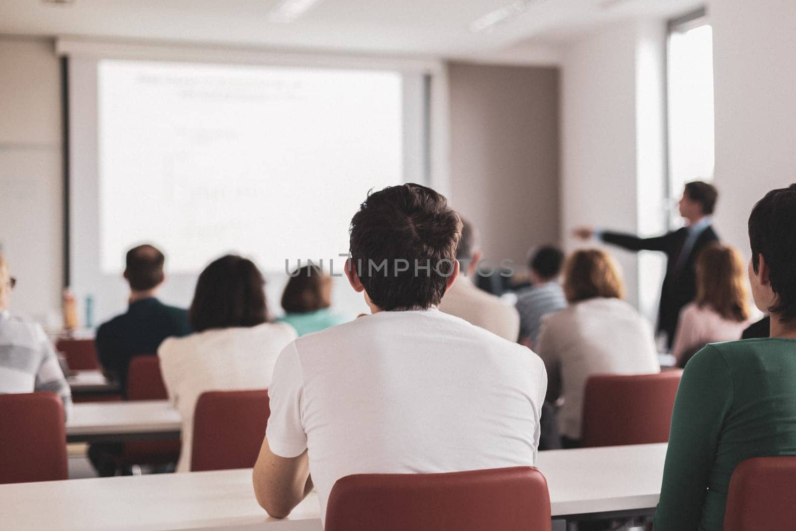 Speaker Giving a Talk at Business Meeting. Audience in the conference hall. Business and Entrepreneurship. Copy space on white board.