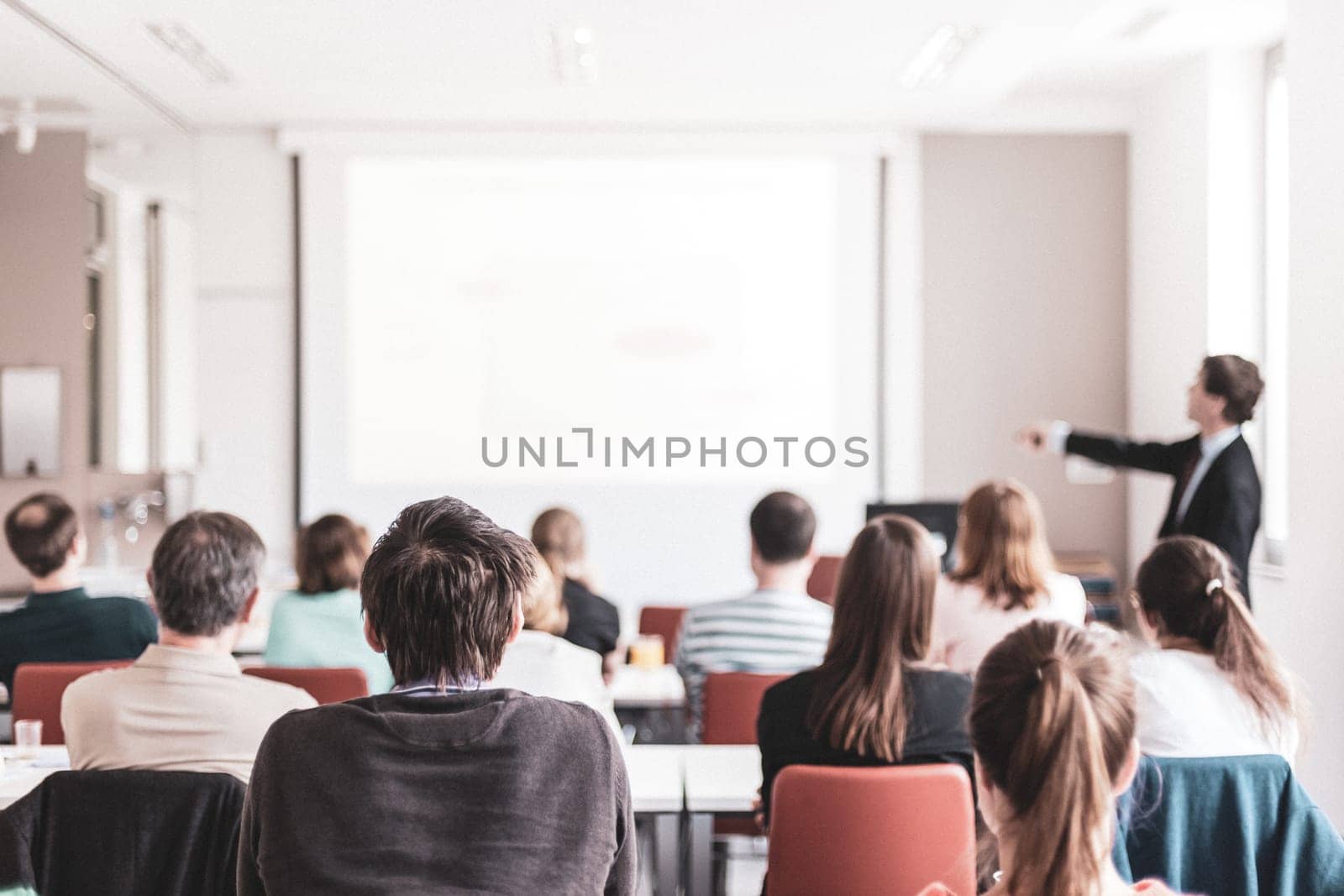 Speaker Giving a Talk at Business Meeting. Audience in the conference hall. Business and Entrepreneurship. Copy space on white board.