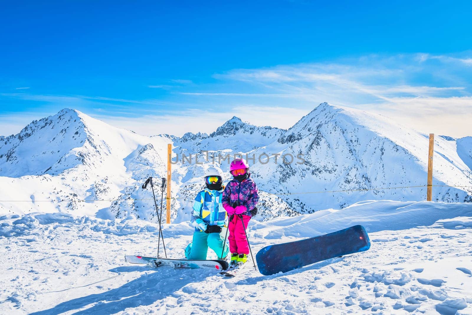 Mother and daughter on ski, winter holidays, with beautiful snow capped mountains in the background in Andorra, El Tarter, Pyrenees Mountains