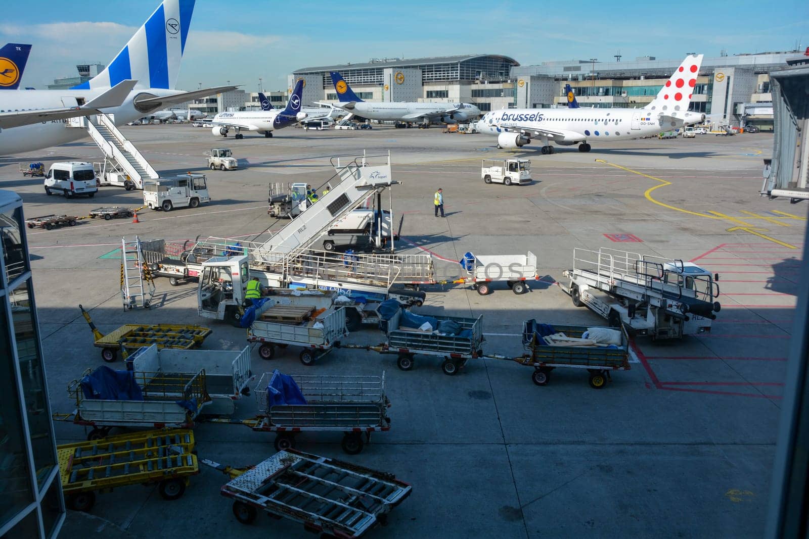 Frankfurt Airport Germany August 02, 2022 - Airplanes and some luggage trolleys at the terminal
