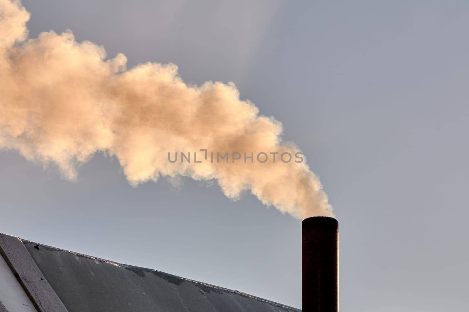 smoke is coming from the chimney of the bourgeoisie. the stove is being heated. High quality photo