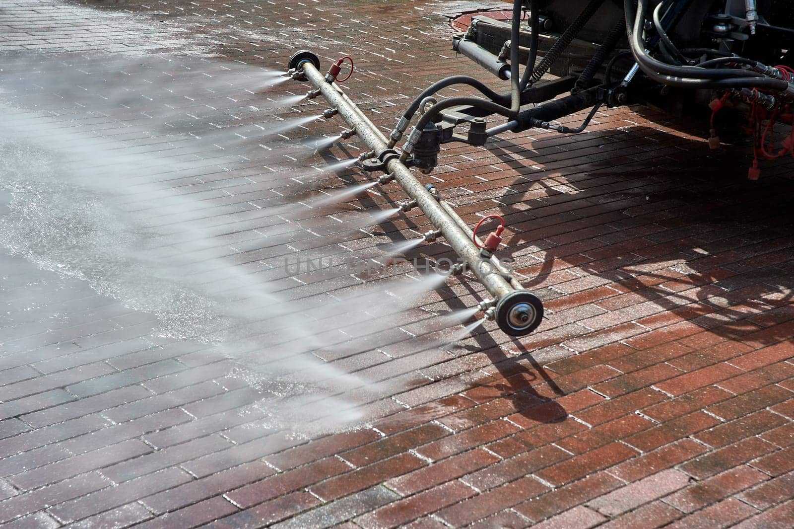 A special machine washes city paths and roads with water. High quality photo