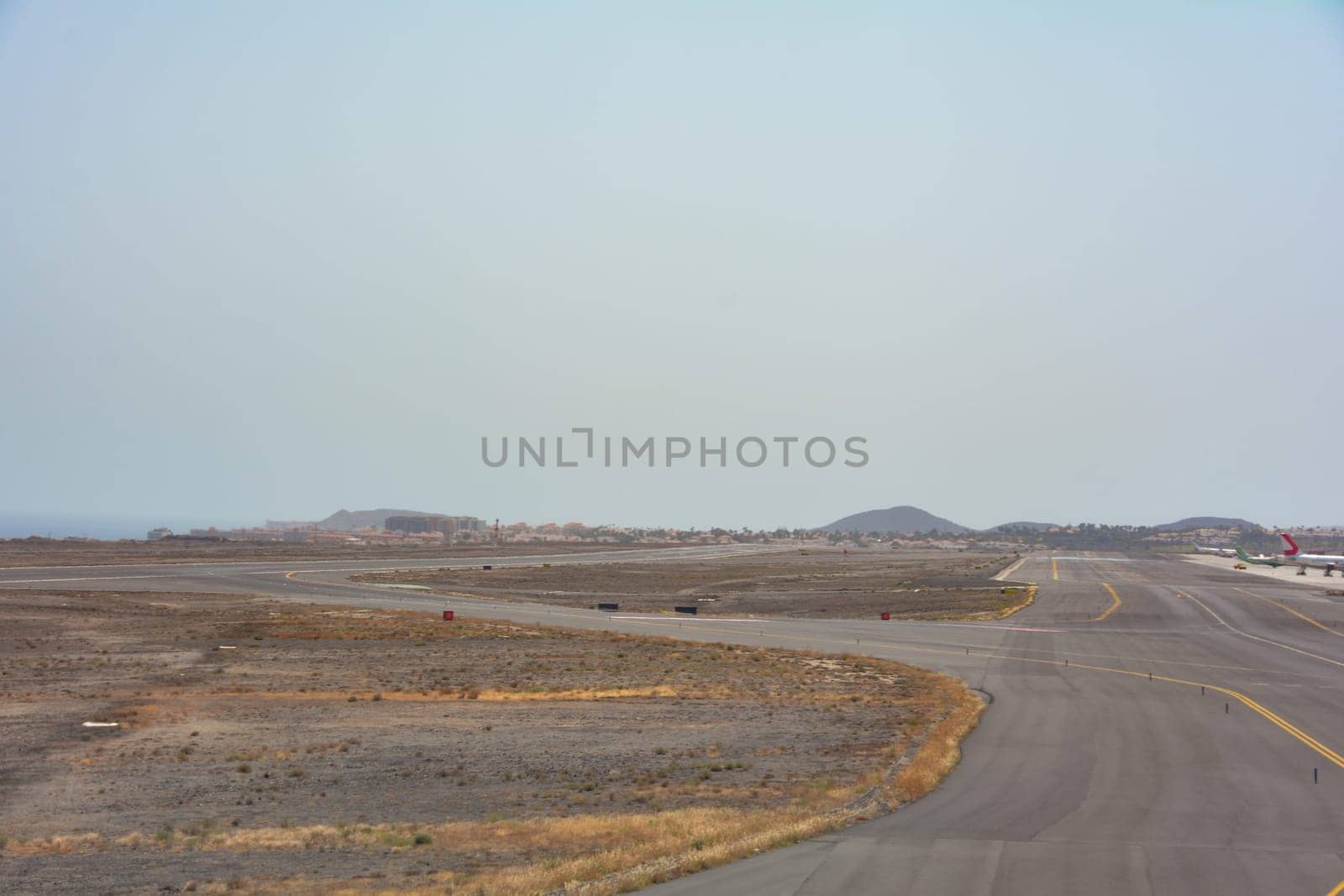 View from a cloudy airplane window on approach to land on the runway of Reina Sofía Airport, Tenerife, Spain