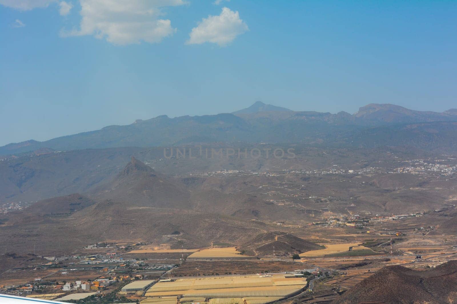 View from a murky airplane window on approach to Tenerife South Airport, Spain. Overlooking the island's countryside.