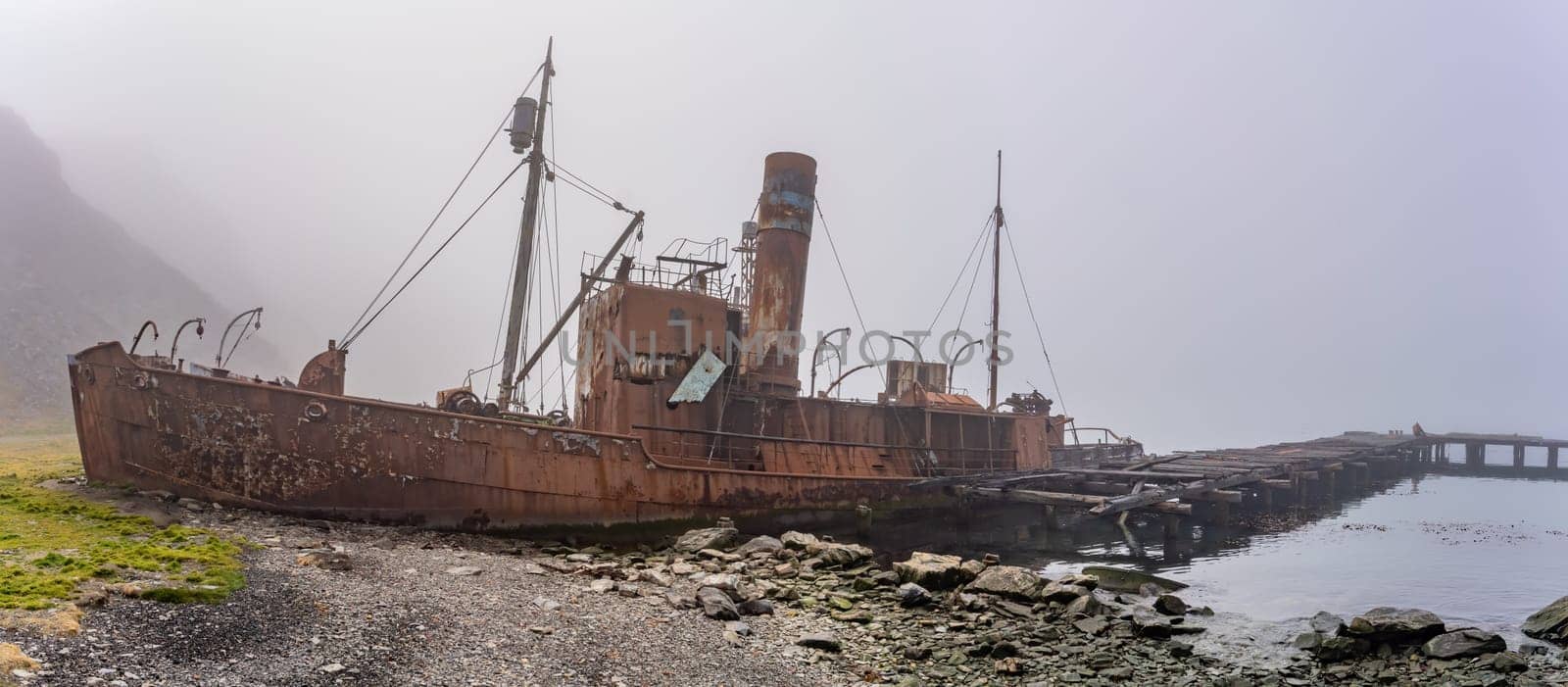 Old, rusty whaling ships and processing facilities at a now abandoned whaling station in Grytviken -on the island of South Georgia.