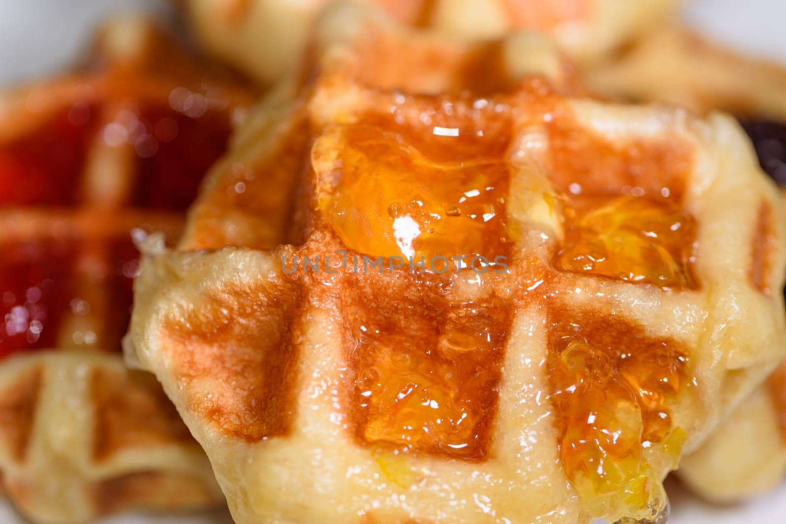 Close up of fresh waffles topped with delicious sweet pineapple jam on top. Making homemade food or dessert at home