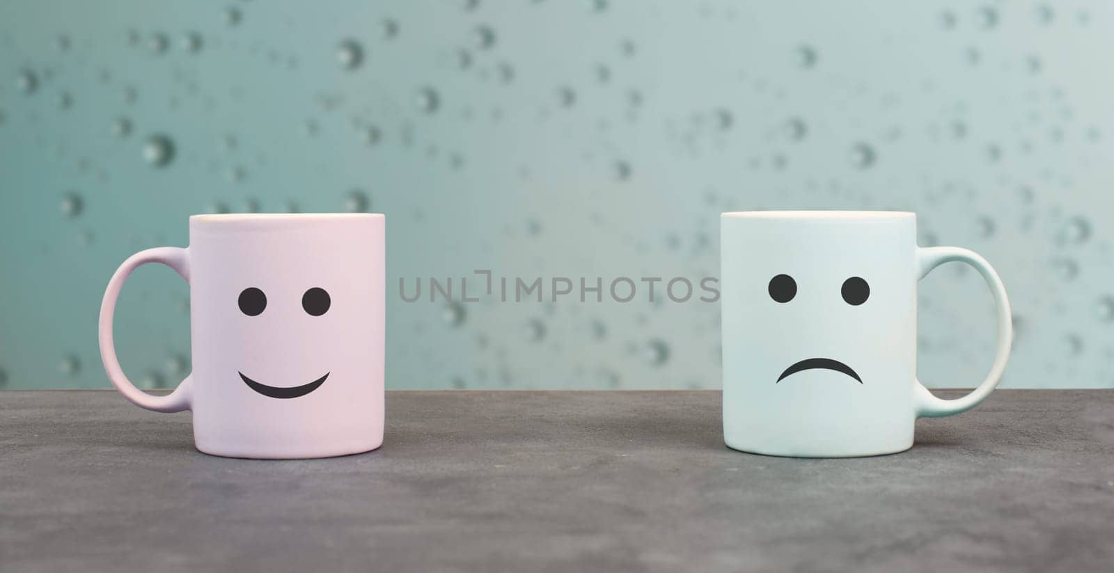 Happy and sad face, cups on a window sill, hot drink on a rainy day, relationship and friendship concept