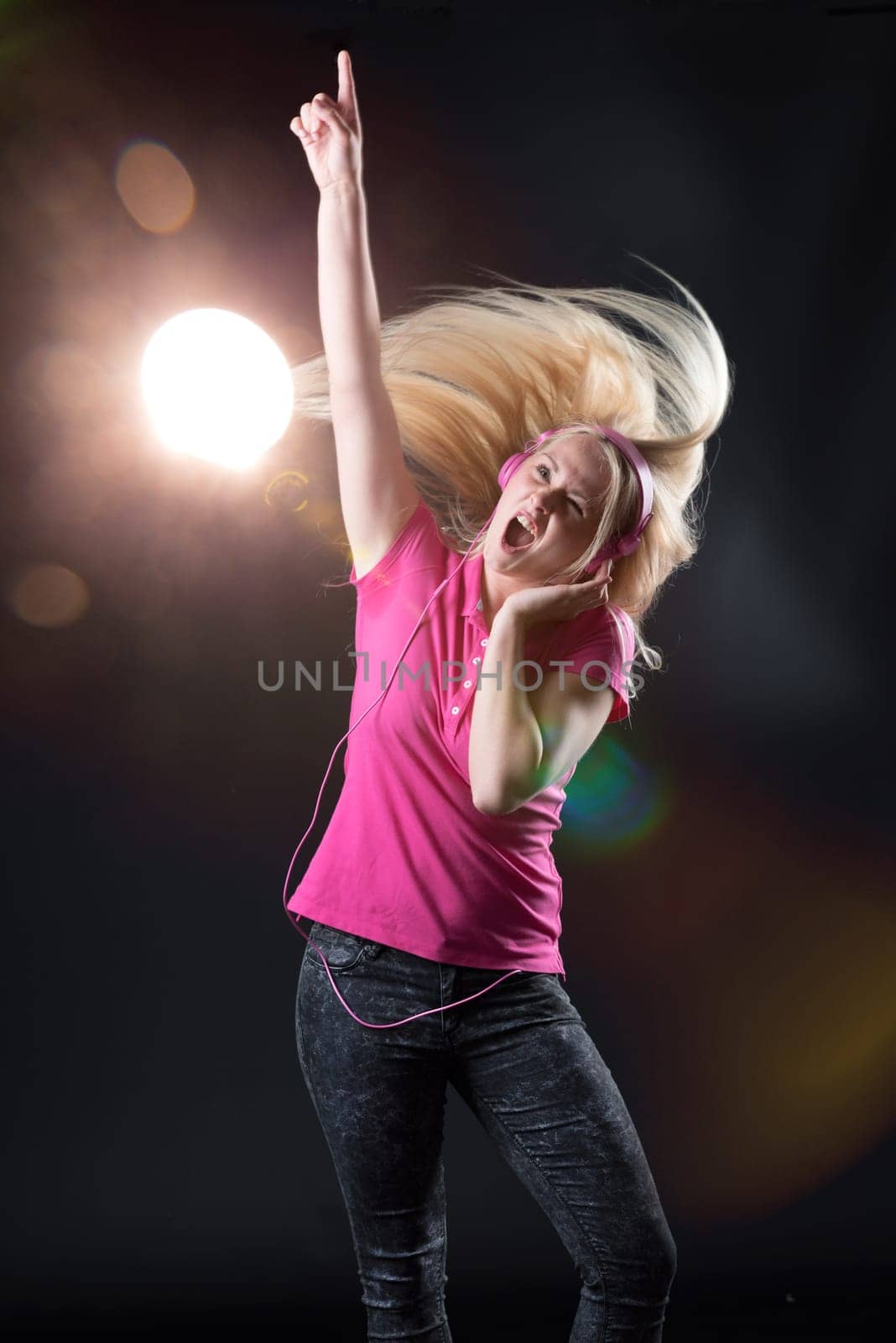 Young woman in stage light rocks off