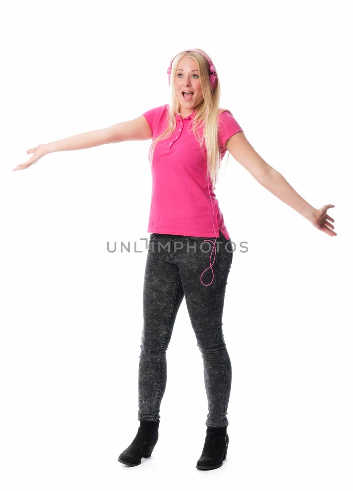 Young woman listens to music through headphones and sings along
