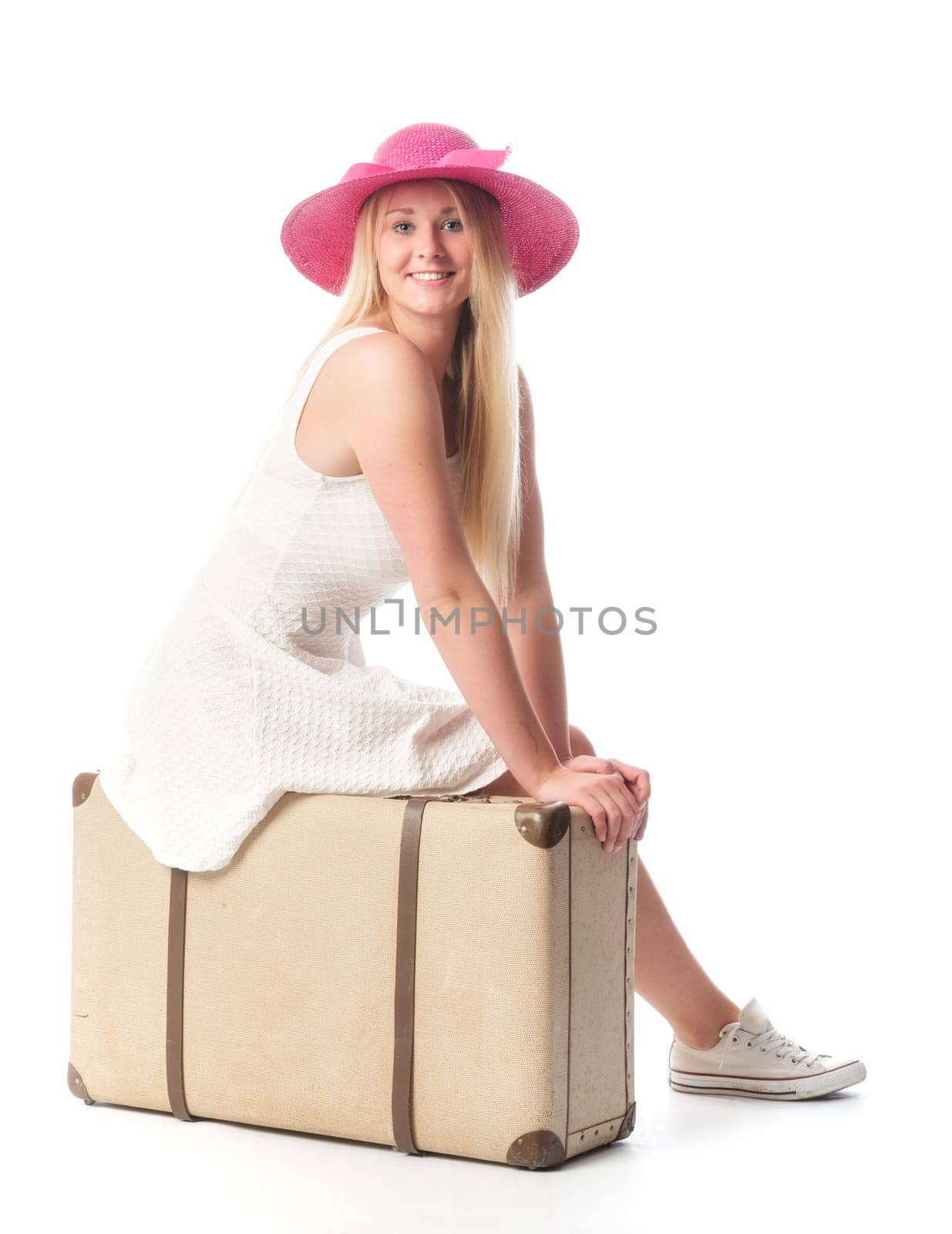 Girl sits on a suitcase and waits