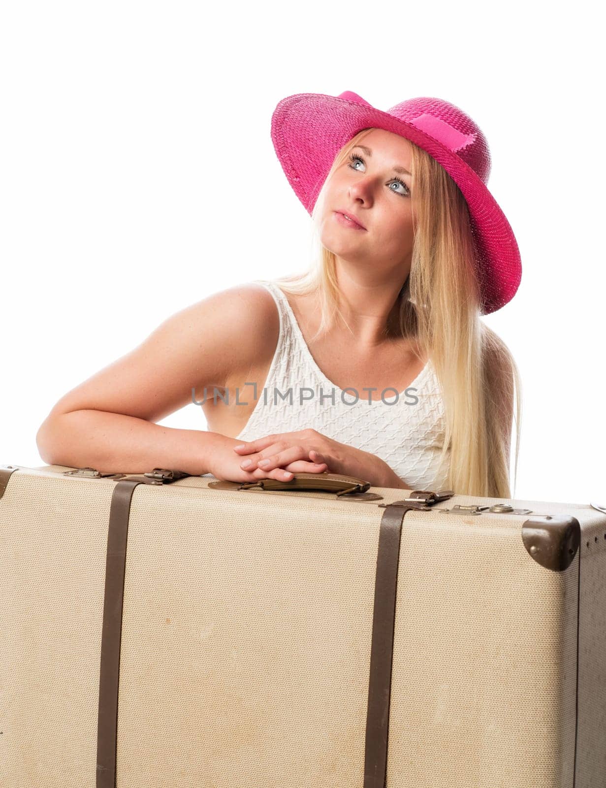 Girl sits in front of suitcase and looks dreamy