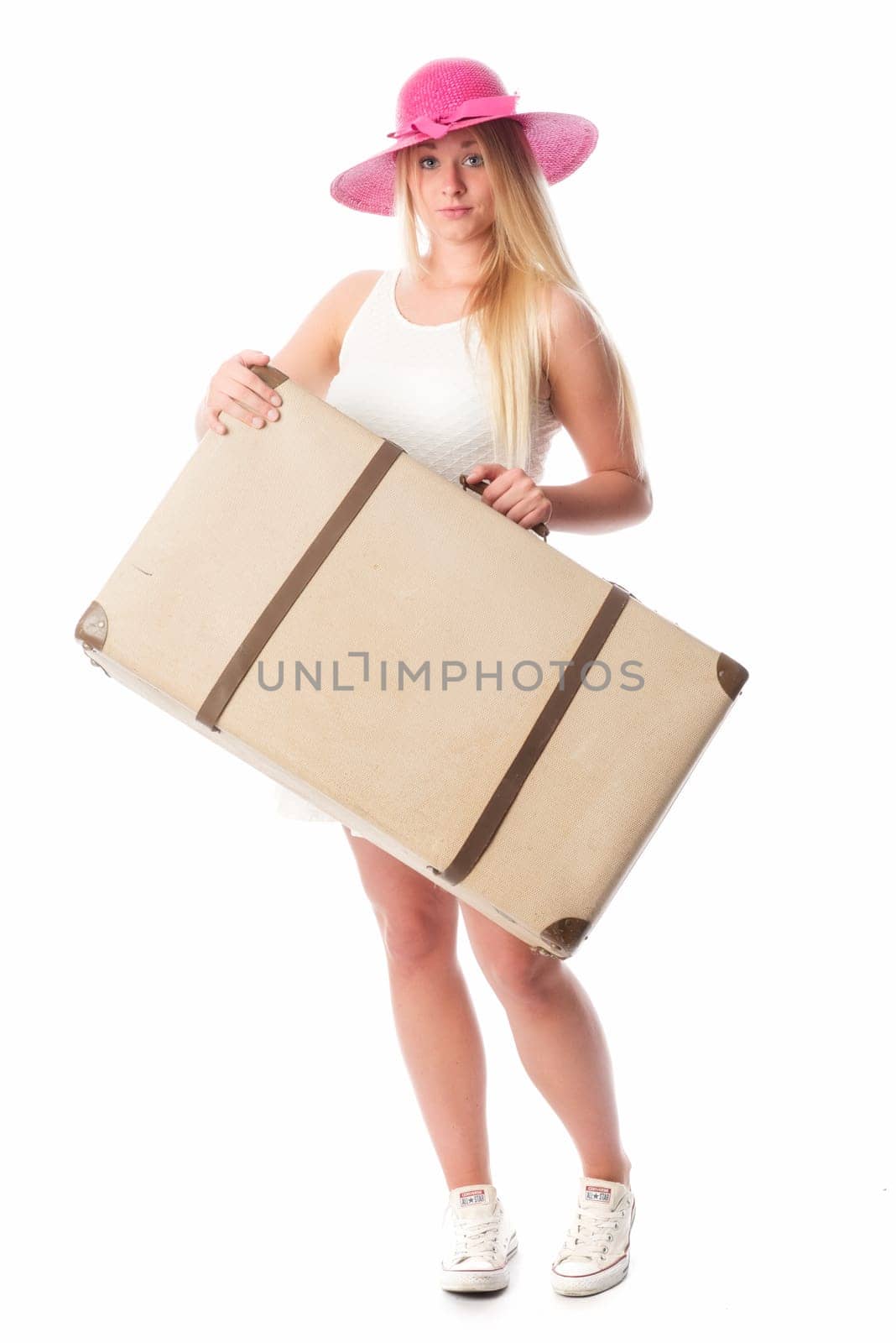 Young woman with straw hat carries a suitcase