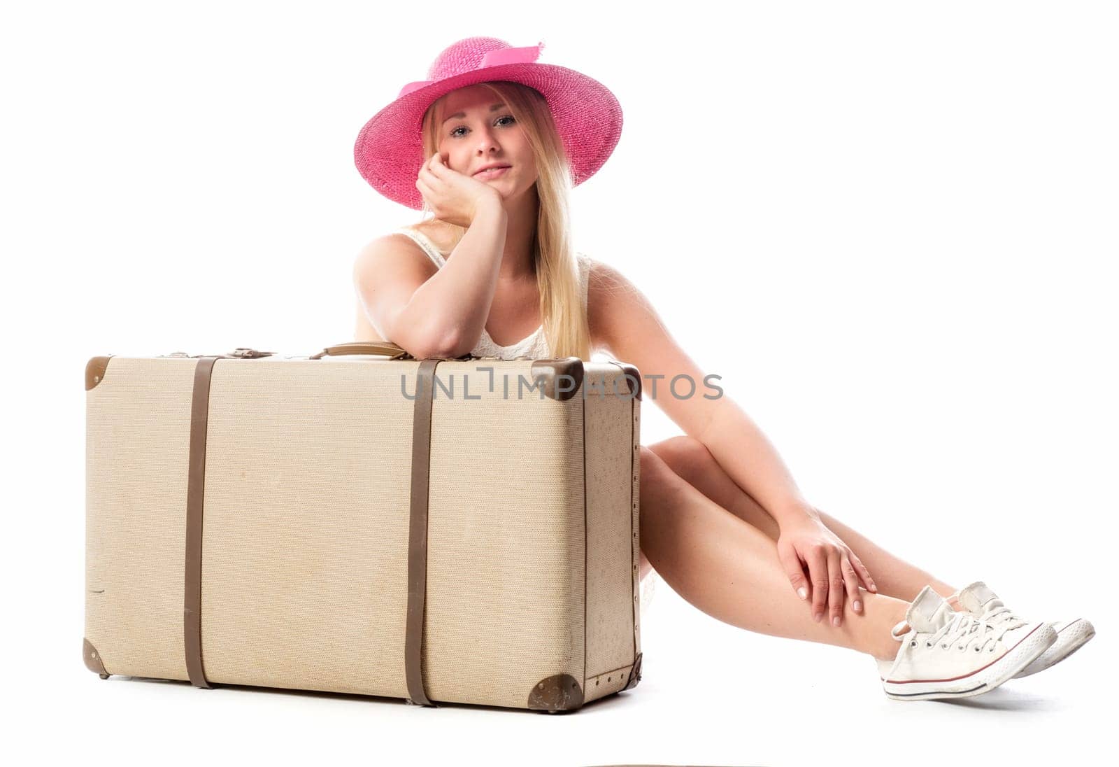 Girl sits in front of a suitcase and waits