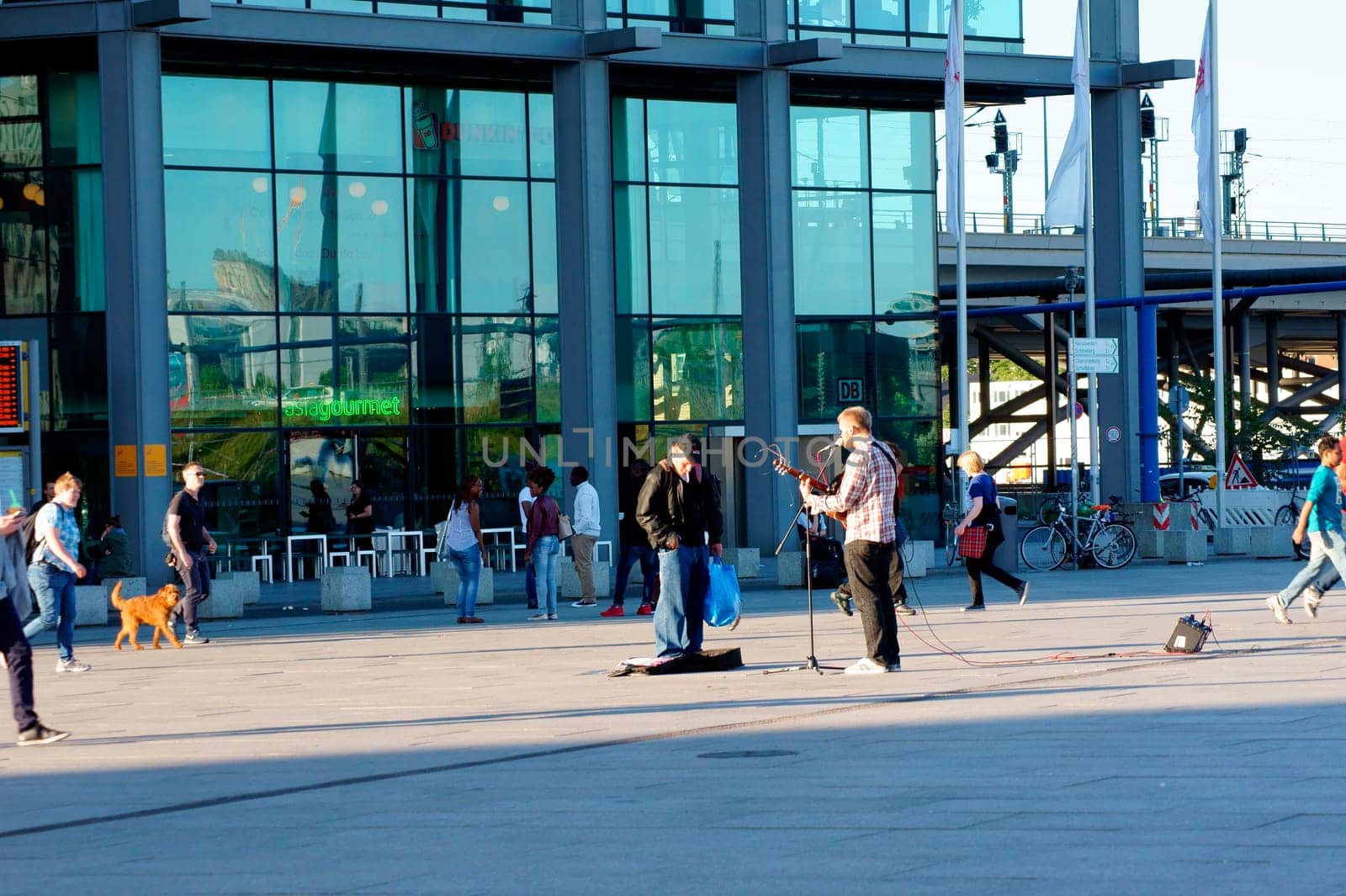 Berlin,Germany – June 04,2015: A street musician plays the guitar in front of travellers and audiences and sings for money at Berlin Central Station on June 4,2015 in Berlin.