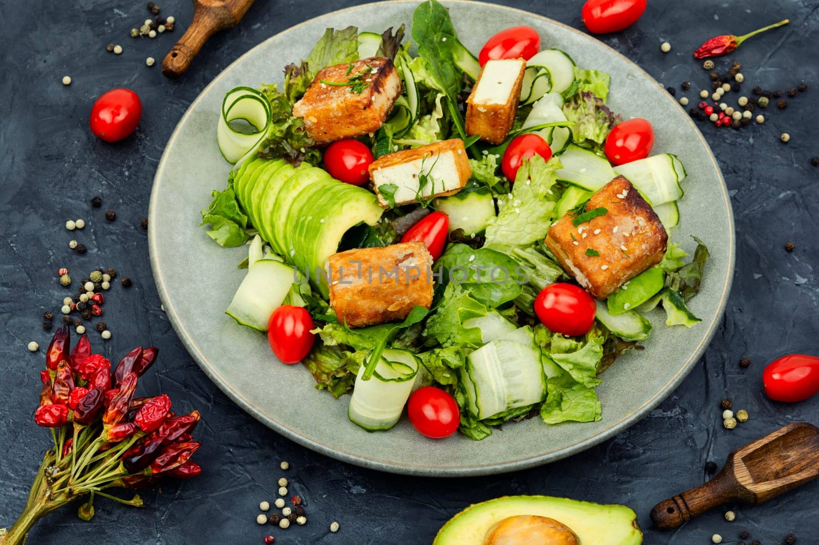 Tasty salad of greens, cucumber, avocado, tomatoes and grilled tofu soy cheese. Healthy Vegetarian Meals