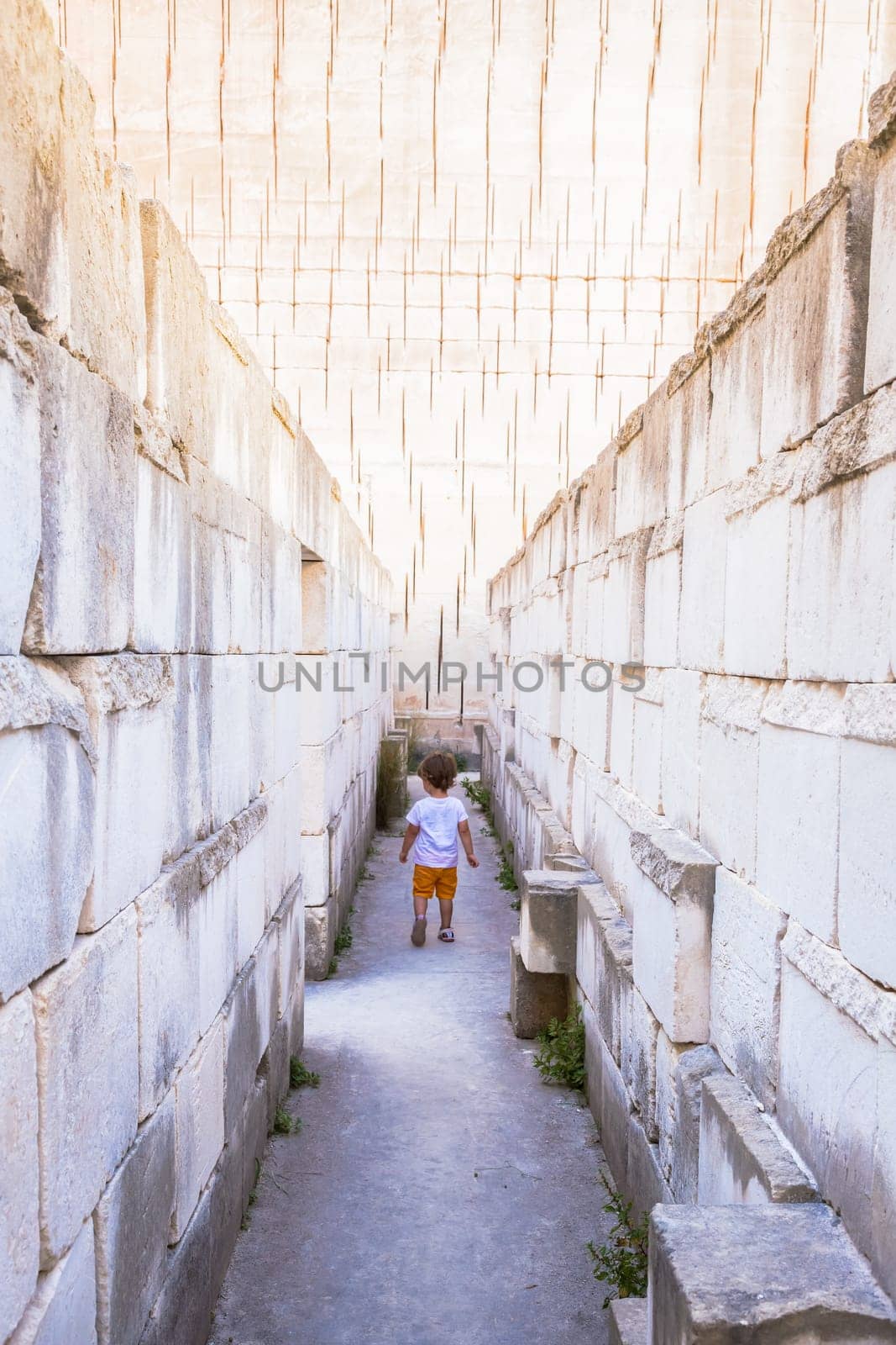 Caucasian young kid walking with labyrinth perspective. Conceptual image for dangerous situation during childhood.