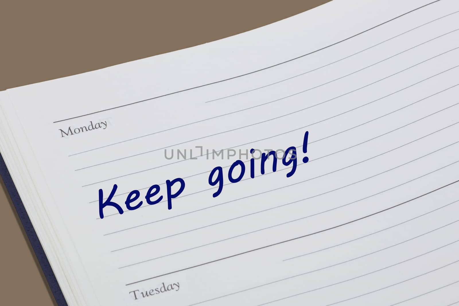 A keep going diary reminder message open on desk