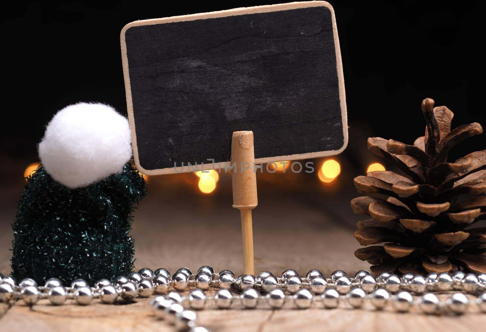 Blank chalkboard with Christmas decoration and Christmas lights bokeh on a wooden table