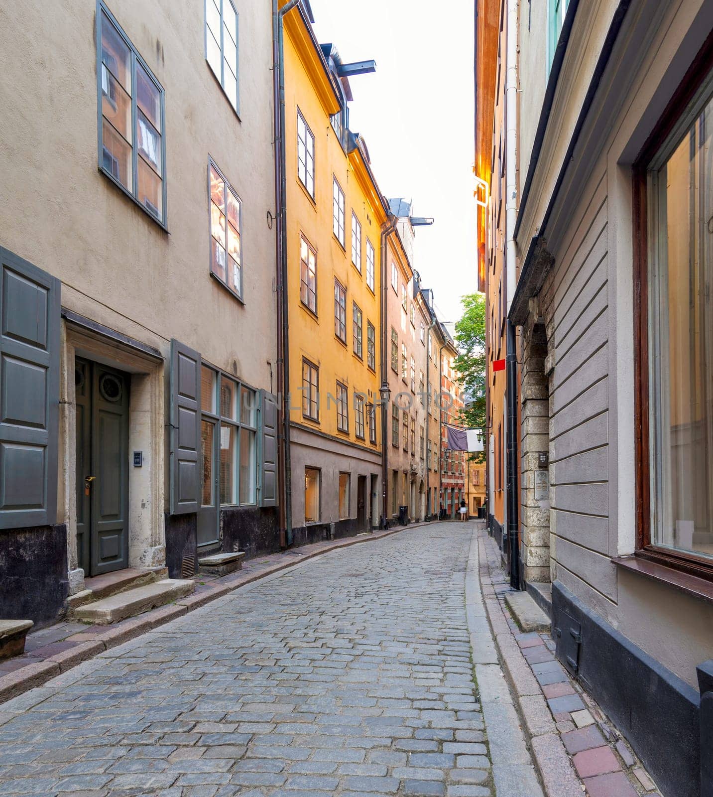 Narrow alley in Gamla stan, the old town of Stockholm, Sweden, with old style orange colored houses and cobblestone street, Stockholm, Sweden