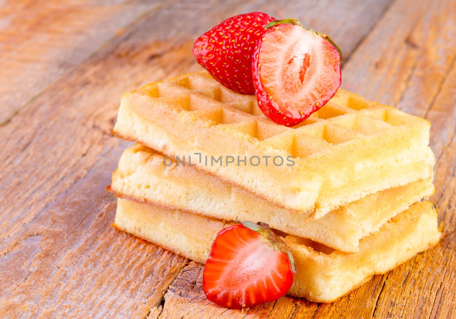 homemade waffles with strawberries  on wooden background