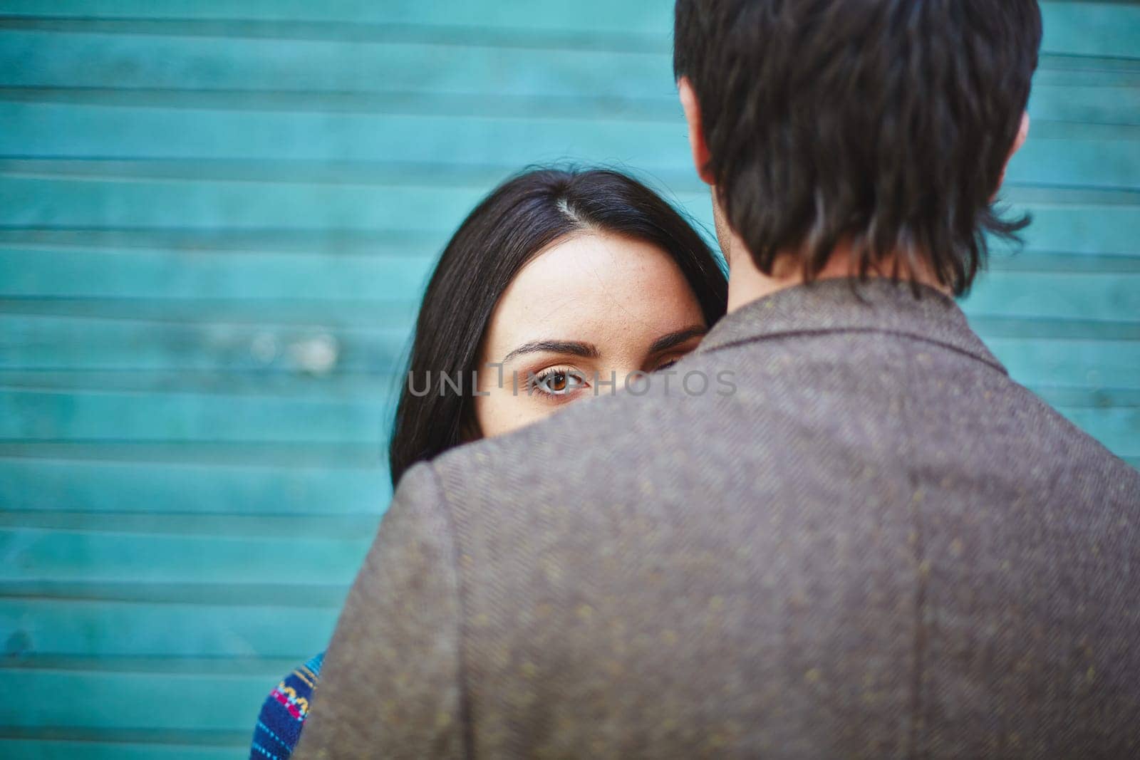 Young woman looking at camera out of man back