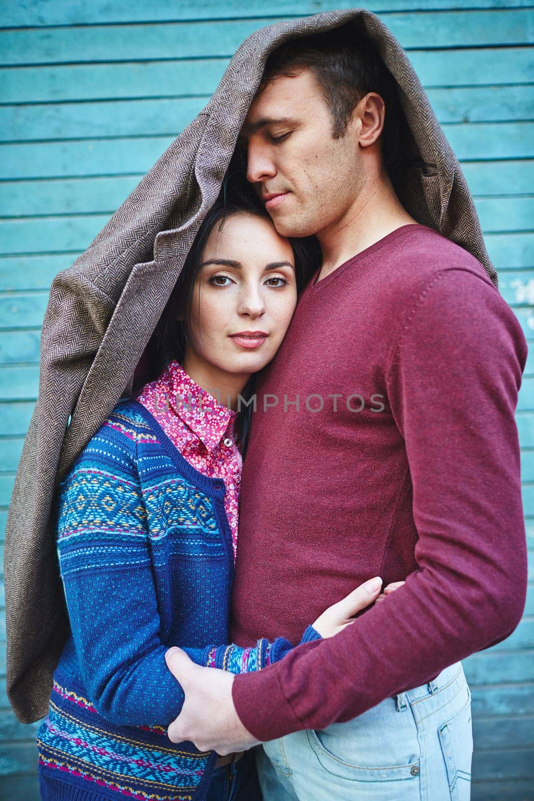 Amorous couple in casualwear covered by jacket