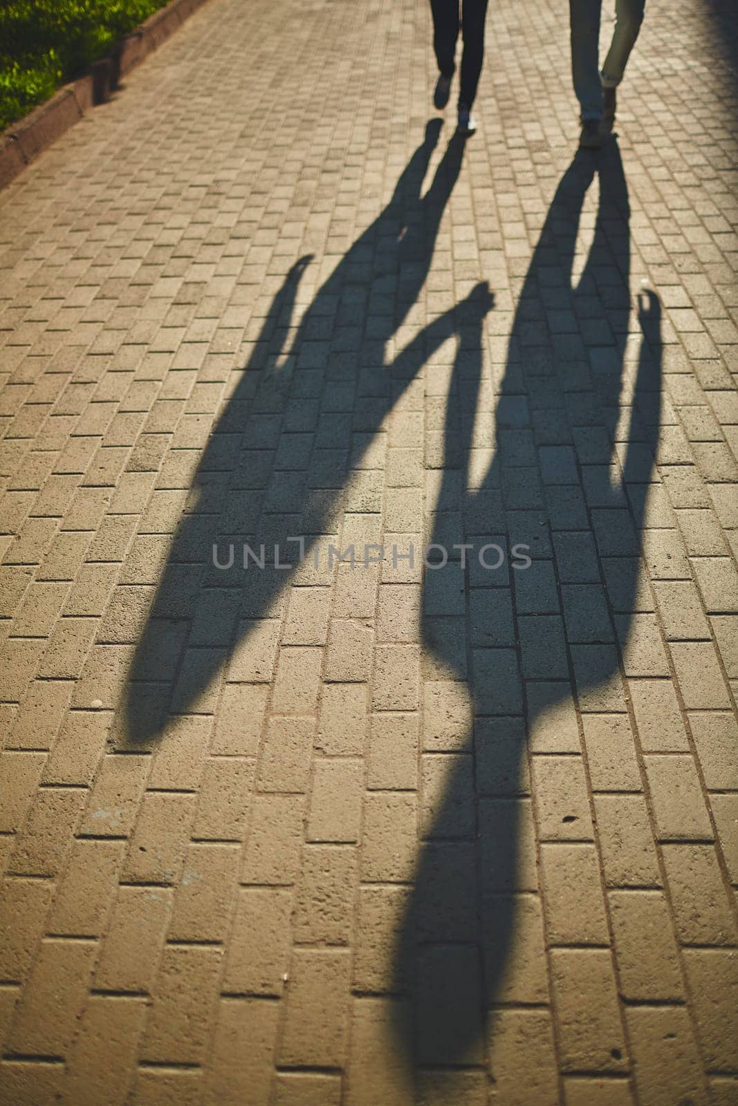 Shadows of amorous dates walking down trottoire