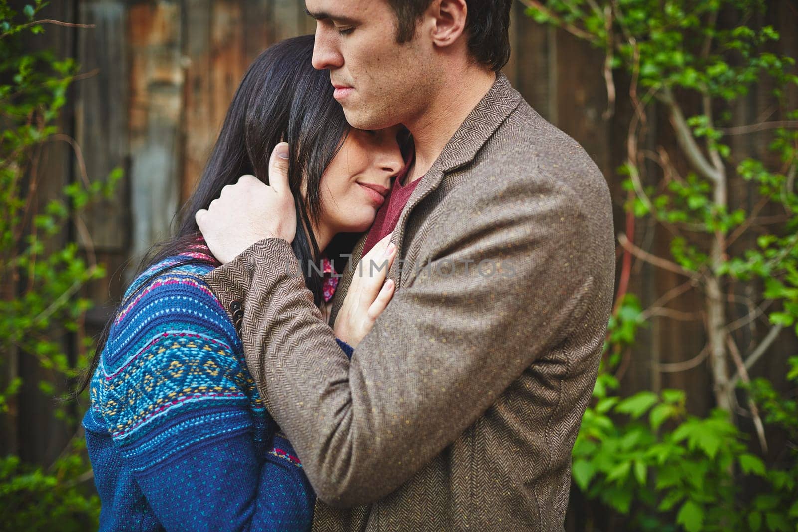 Amorous couple in casualwear cuddling outside