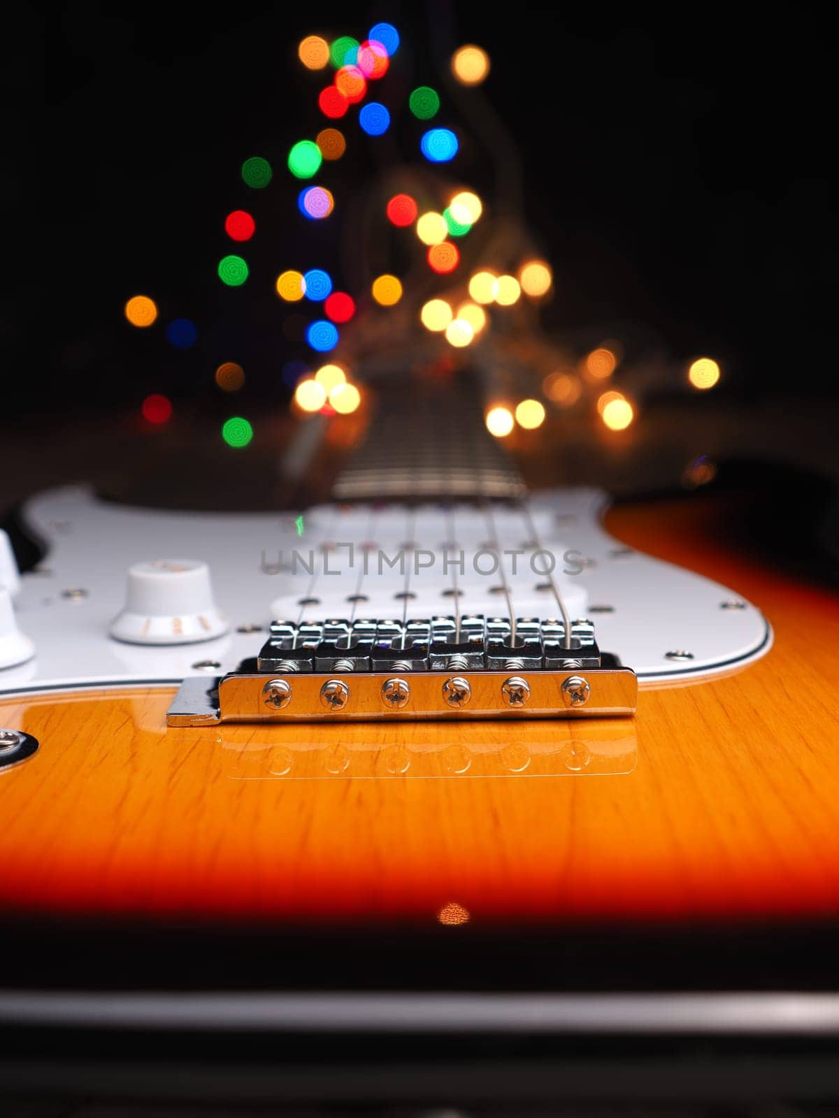 Old used vintage guitar with colorful Christmas lights bokeh background and space for your text