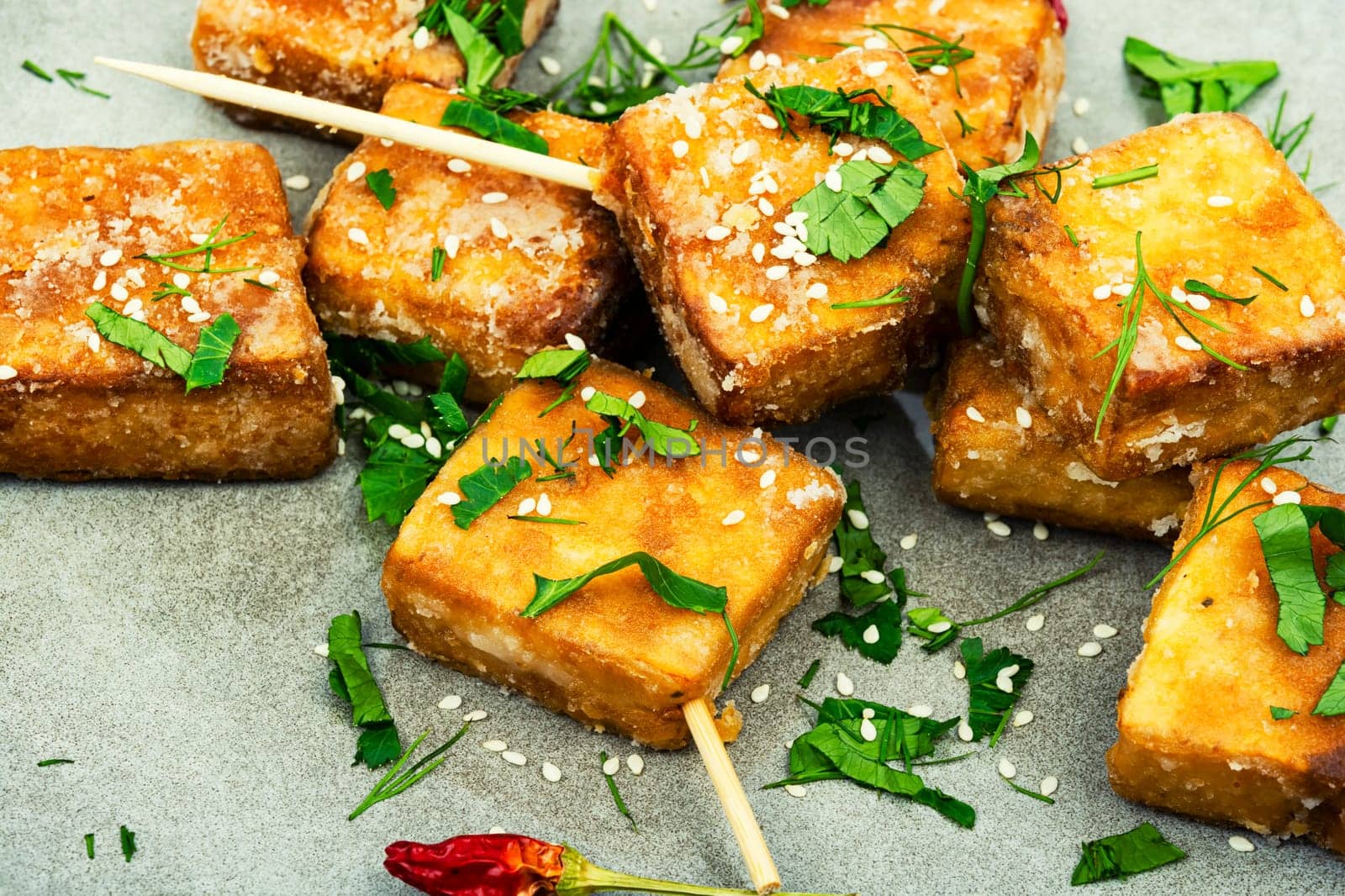 Skewers with roasted tofu cheese with and sesame seeds. Close up
