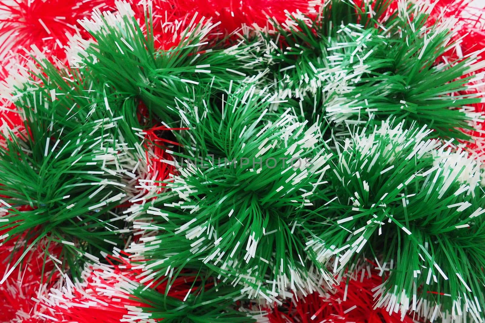 New Year and Christmas decorations, red and green boas for the Christmas tree. Two-color Christmas rain garlands are mixed. Festive decor