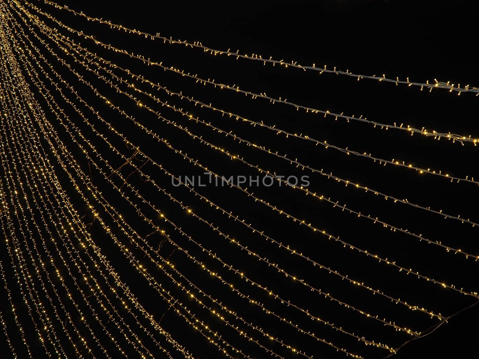 Festive garland. City night light blur bokeh, defocused background. Christmas bokeh. Beautiful lights against the black night sky. Street decoration for New Year and Christmas.