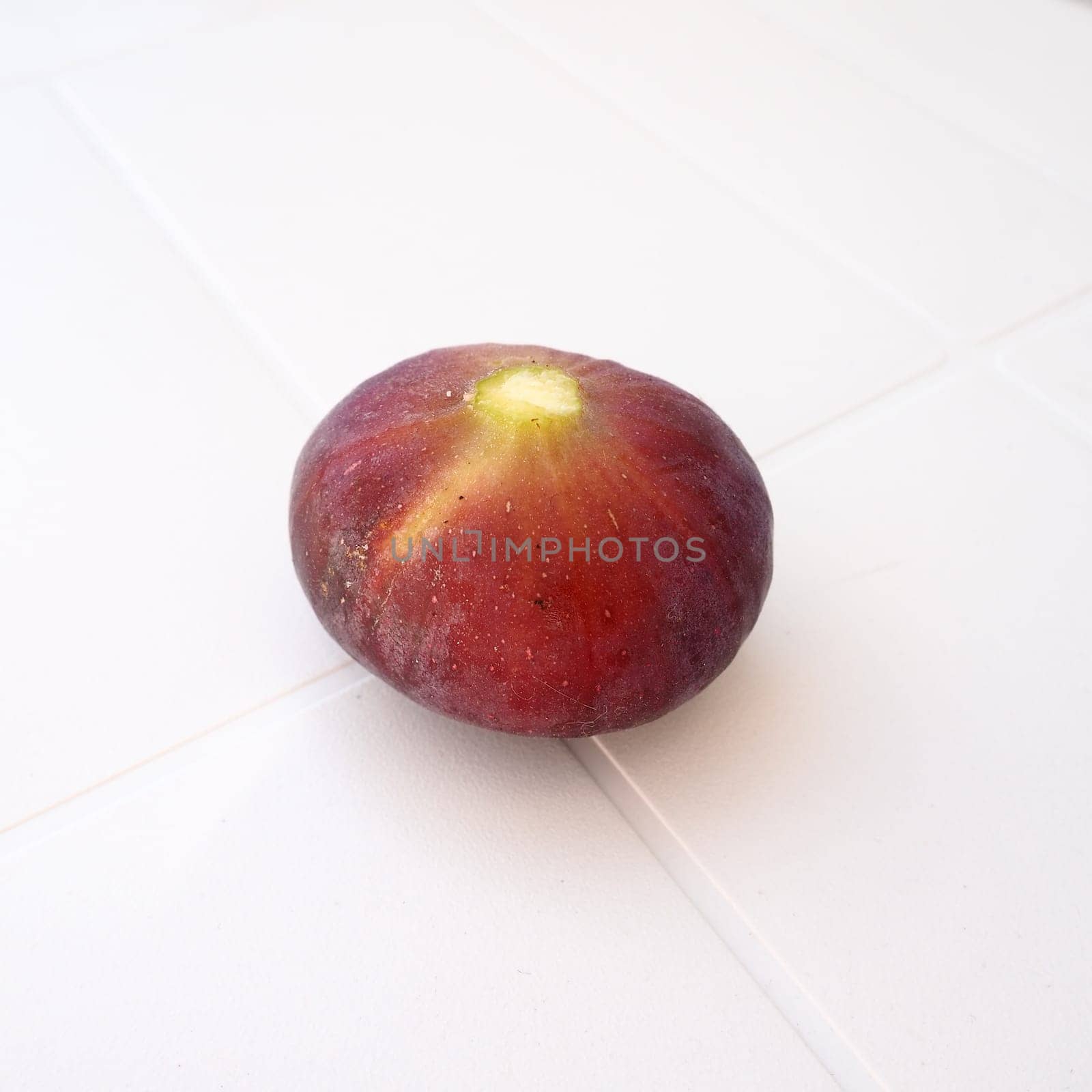 Fig or fig tree, or common fig tree, or Ficus carica is a subtropical deciduous plant of the genus Ficus of the Mulberry family. Ripe purple fig fruits on a light background. Healthy food.