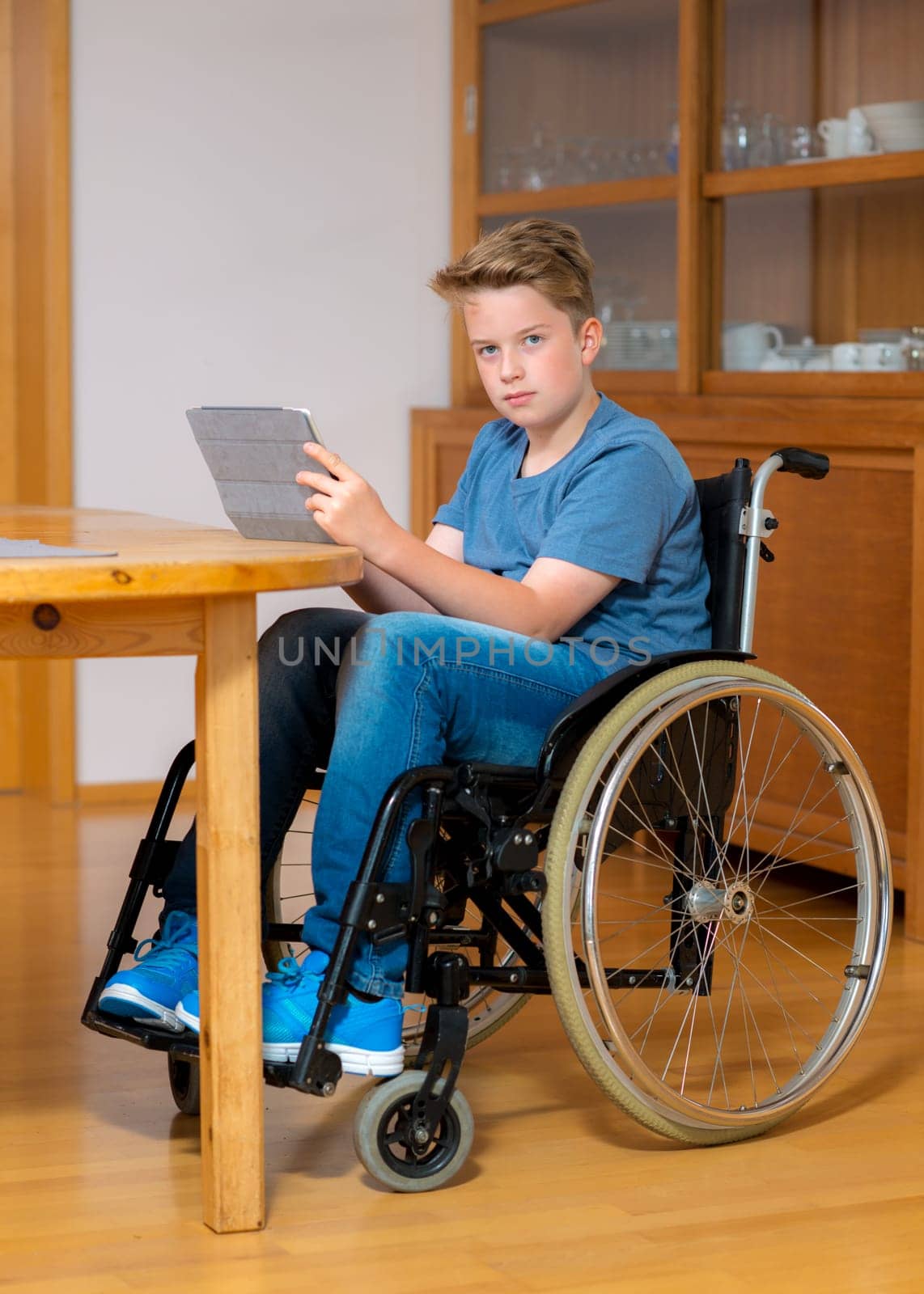 disabled boy in wheelchair doing homework and chatting in the internet
