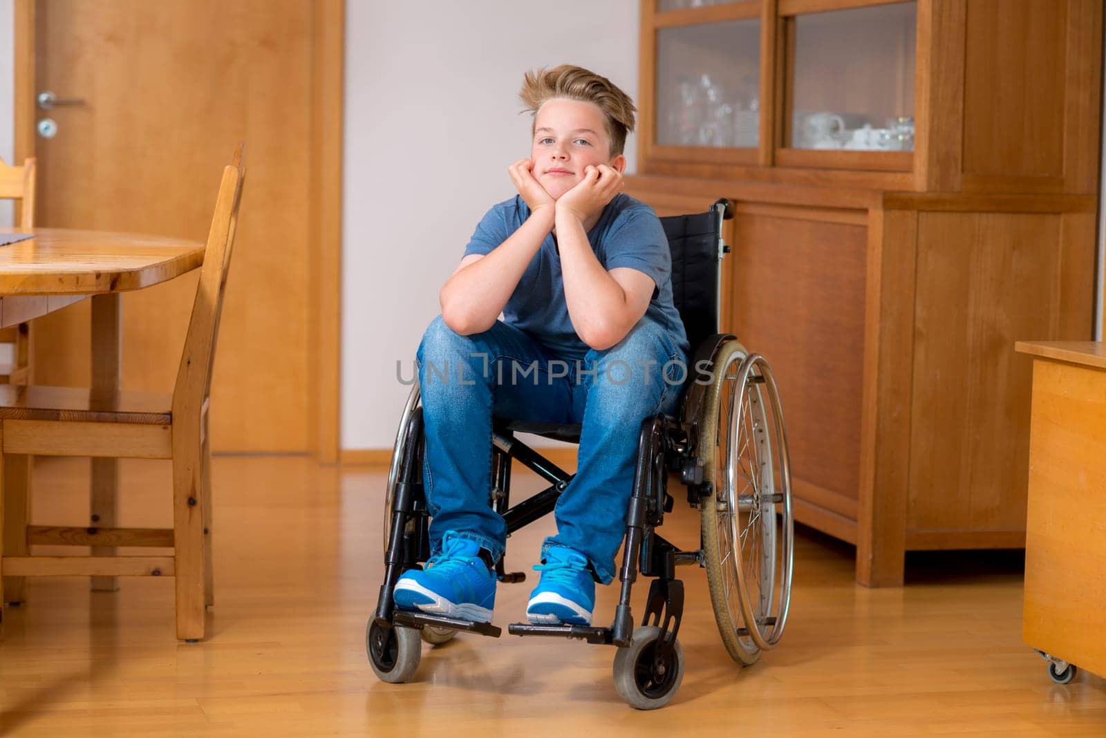 disabled boy in wheelchair at home in the living room