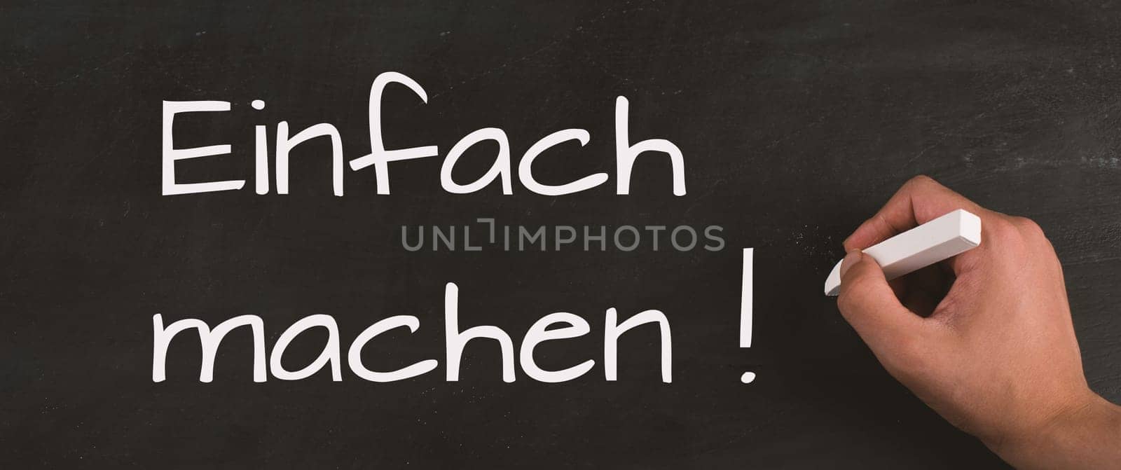Just do it is standing in german language on the chalkboard, coaching concept, motivation and education, time to start
