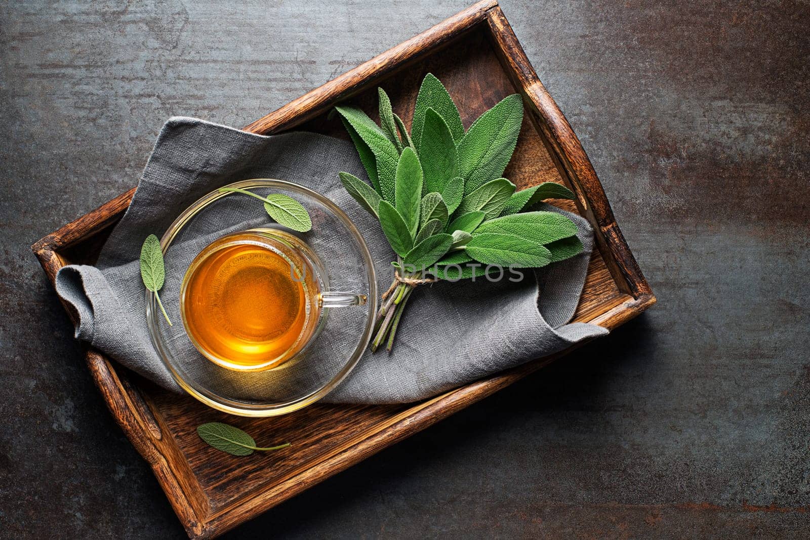 Sage tea in a cup served on a trey close up