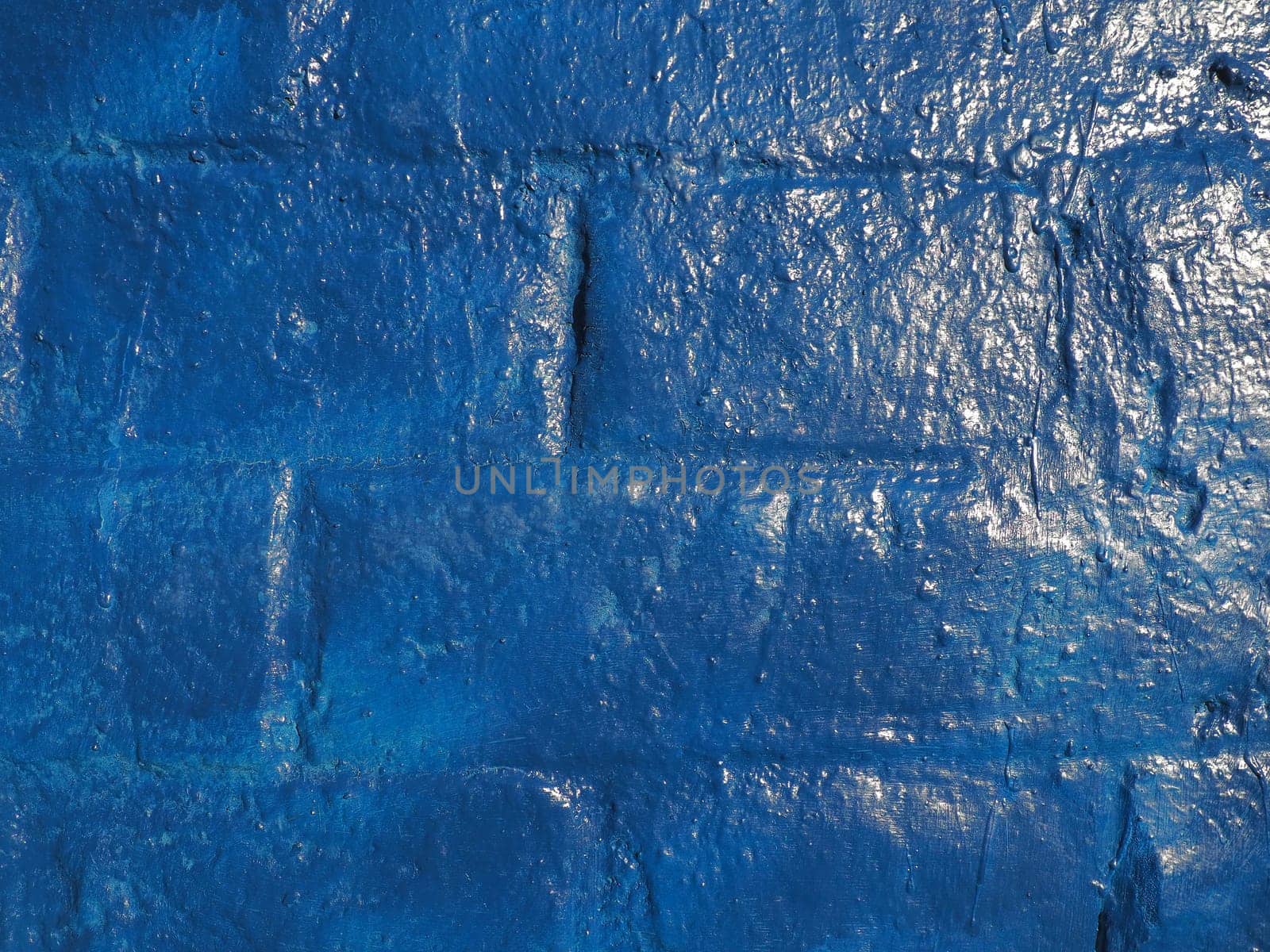 Beautiful blue wall and texture background. Large bricks painted with glossy oil blue paint