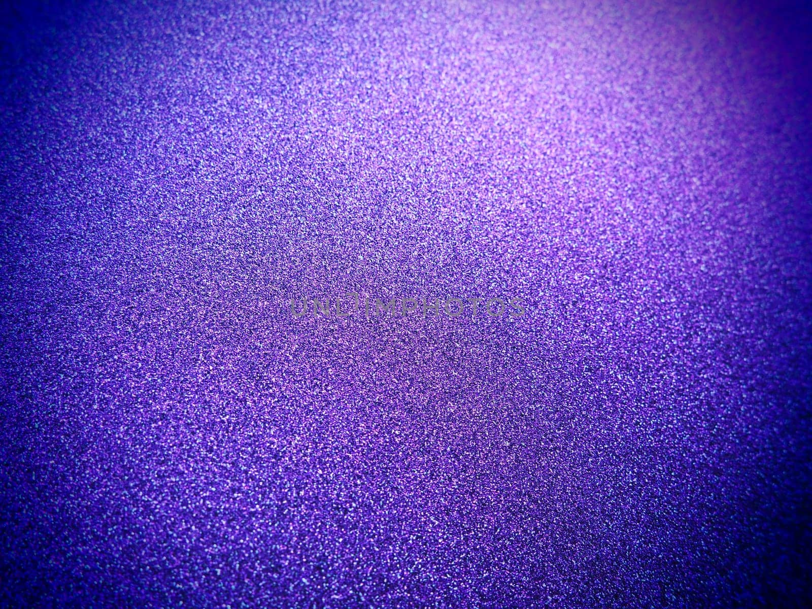 Deep blue. Texture of rough paper or cardboard. Defocused bokeh sparkles and shining. Festive blue background with illuminated sapphire gradient.
