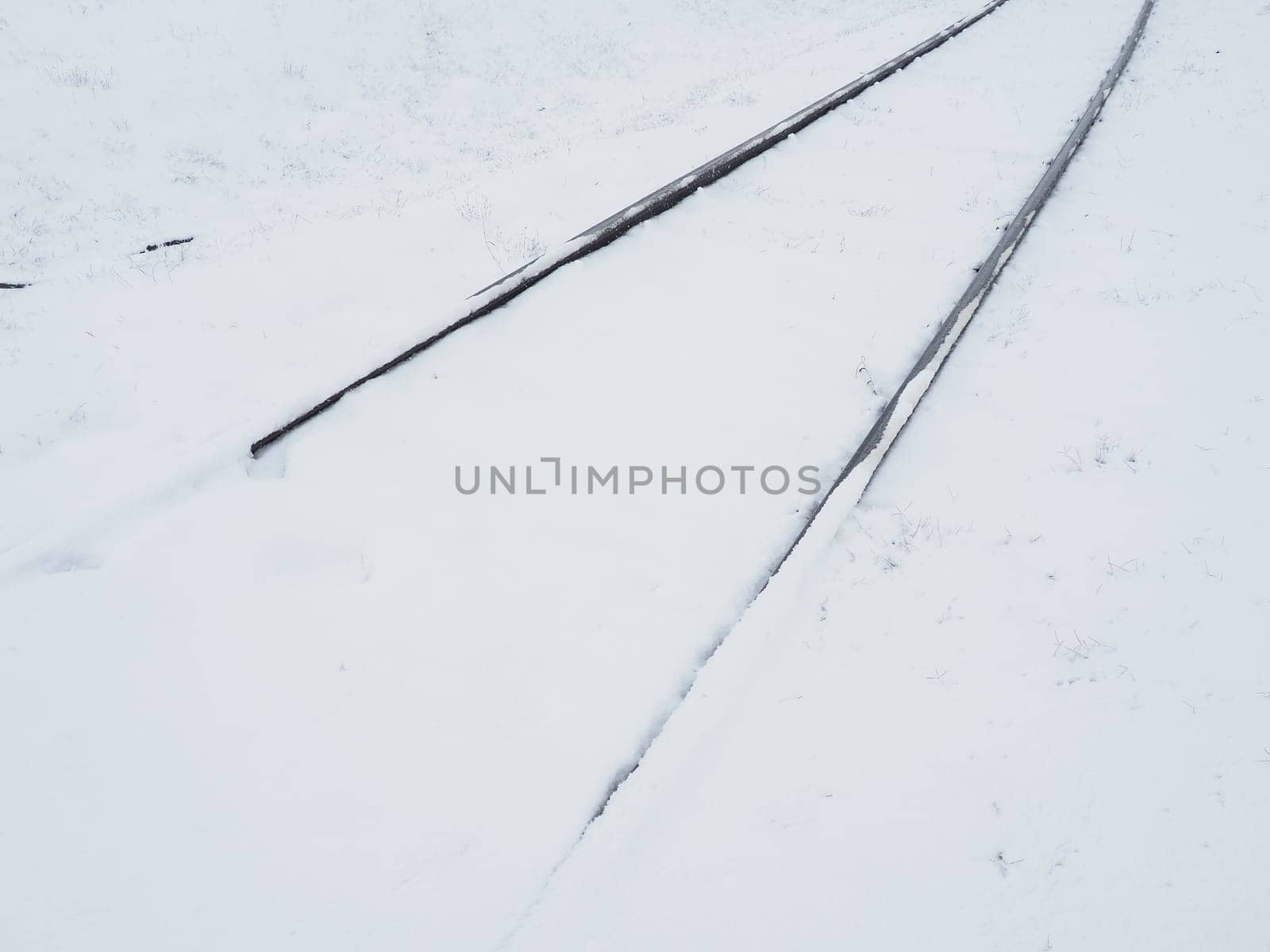 Railway in the snow. Rails covered by a snowstorm. Railway service, snow removal. Transport concept. Snowdrifts and drifts. Difficult weather conditions.